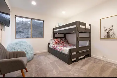 a bedroom with a bunk bed and a chair at Mammoth Estates 233 in Mammoth Lakes