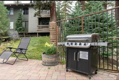 a grill sitting on a patio next to a chair at Seasons Four 110 in Mammoth Lakes