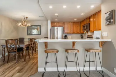 a kitchen with wooden cabinets and a kitchen island with bar stools at Silver Bear 32 in Mammoth Lakes