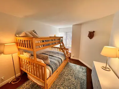 a bedroom with a bunk bed with two lamps at Cozy Mammoth Ski Condo with Mtn Views and Hot Tub in Mammoth Lakes