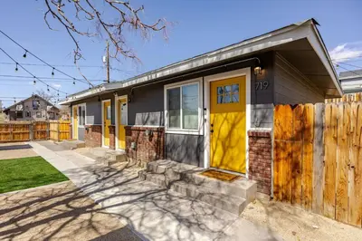 a house with a yellow door and a fence at 719 Mid-Town Retreat in Reno