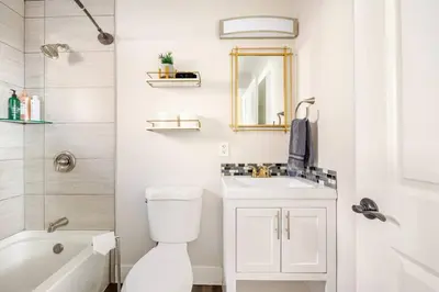 a bathroom with a toilet and a sink and a mirror at 721 Cozy Mid-Town Hideaway in Reno