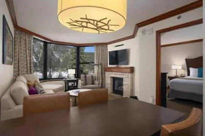 a living room with a dining table and a bedroom at Ski-InandSki-Out! 2BR Condo with Resort Pools, Spa in Olympic Valley
