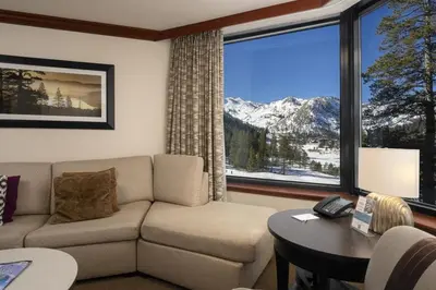 a living room with a couch and a large window at Ski-InandSki-Out! 2BR Condo with Resort Pools, Spa in Olympic Valley