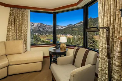a living room with a couch and chairs and a large window at Sweeping Views and Access to Slopes Everline Condo in Olympic Valley