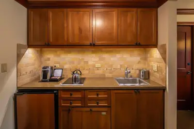a kitchen with wooden cabinets and a sink at Sweeping Views and Access to Slopes Everline Condo in Olympic Valley