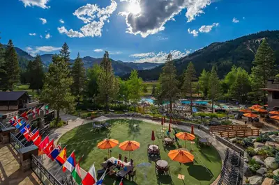 an aerial view of a resort with tables and umbrellas at Sweeping Views and Access to Slopes Everline Condo in Olympic Valley
