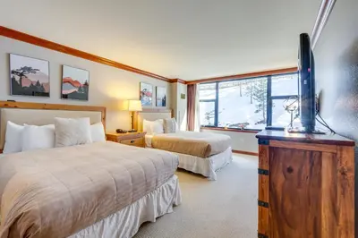 a hotel room with two beds and a flat screen tv at Ski-InandSki-Out! 2BR Resort Condo with Pool, Hot Tub in Olympic Valley