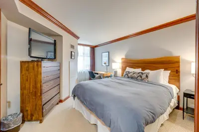 a bedroom with a large bed and a flat screen tv at Ski-InandSki-Out! 2BR Resort Condo with Pool, Hot Tub in Olympic Valley