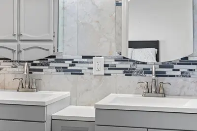 a bathroom with two sinks and a mirror at Spacious 6 BR • Patio + Deck • Sleeps 13 in Sacramento