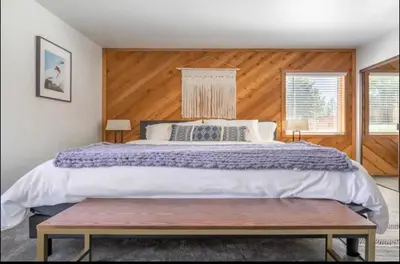 a bedroom with a large bed with a wooden wall at Snowcreek 1 in Mammoth Lakes