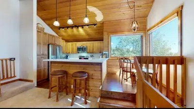 a kitchen with wooden walls and a table and chairs at Snowcreek 222 in Mammoth Lakes