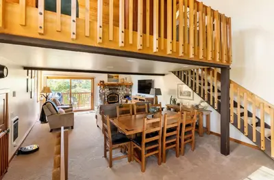 a dining room with a wooden table and a staircase at Snowcreek 222 in Mammoth Lakes