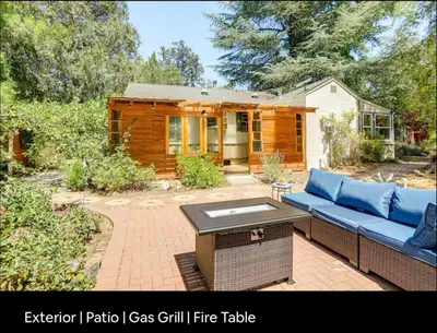 a log cabin with a blue couch and a table at Amador Wine Country Cottage in Fiddletown