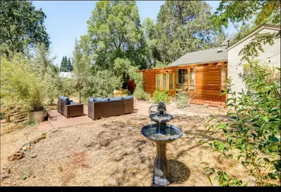 a backyard of a house with a birdbath in the yard at Amador Wine Country Cottage in Fiddletown