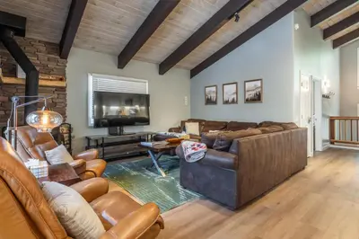 a living room with leather furniture and a flat screen tv at Chateau Blanc 1 in Mammoth Lakes