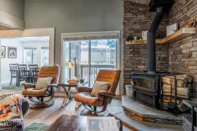 a living room with a brick wall and a wood stove at Chateau Blanc 1 in Mammoth Lakes