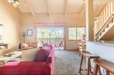 a living room with a red couch and a fireplace at Western Slopes Villas 18 in Mammoth Lakes