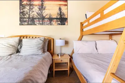 two beds in a room with two bunk beds at Western Slopes Villas 18 in Mammoth Lakes