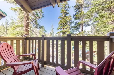two chairs sitting on a deck with trees in the background at Western Slopes Villas 18 in Mammoth Lakes