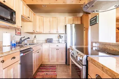 a kitchen with wooden cabinets and a stainless steel refrigerator at Western Slopes Villas 18 in Mammoth Lakes