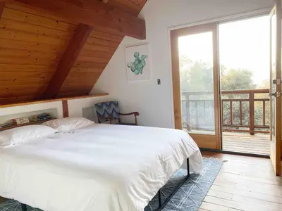 a bedroom with a white bed and a large window at Casa Manzanita in Midpines! 26 miles to Yosemite! in Midpines