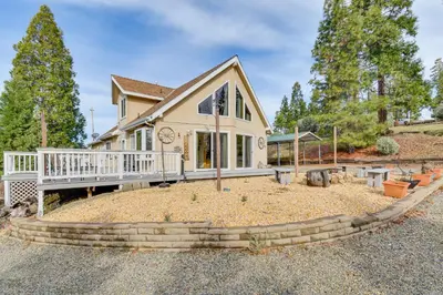 a house with a porch and a yard at Deck and Wooded Views 5-Acre Auberry Retreat! in Auberry