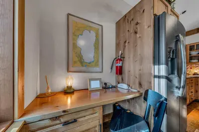 a wooden desk in a kitchen with a refrigerator at Cozy Tahoe Getaway - Walk to Lake & Quiet Deck in Carnelian Bay