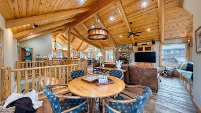 a dining room and living room with a wooden ceiling at Truckee Mountain Cabin with Hot Tub Game Room Forest Views Gray Wolf Lodge by AvantStay in Truckee