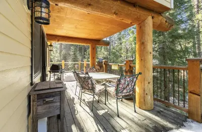 a wooden deck with a table and chairs on it at Big Foot Hide Out Shaver Lake Mts in Shaver Lake