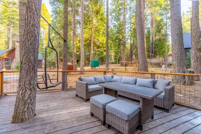 a patio with a couch and a table and some trees at Cozy Tahoma Family Cabin in the Pines Sleeps 6 Pets in Tahoma