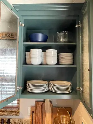 a cupboard with plates and bowls in it at The Little Dipper Cabin in Shaver Lake
