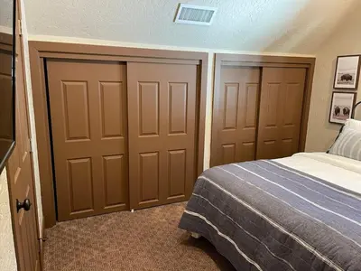 a bedroom with two closet doors and a bed at The Little Dipper Cabin in Shaver Lake