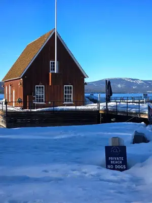 a barn in the snow with a sign in front at Chamberland retreat-Hot Tub, Pool Table, Movie & Ski in Homewood