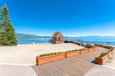 a wooden boardwalk leading to a beach with a church at Chamberland retreat-Hot Tub, Pool Table, Movie & Ski in Homewood