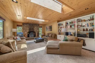 a living room with two couches and a fireplace at Chamberland retreat-Hot Tub, Pool Table, Movie & Ski in Homewood