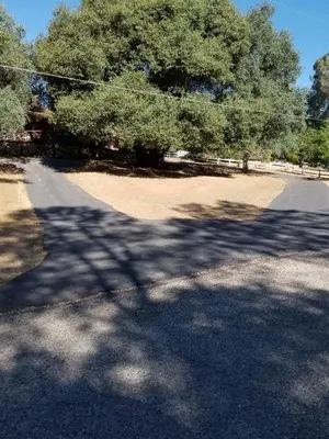 an empty road with trees on the side of it at Red Barn Haven-Your romantic getaway to Yosemite in Oakhurst