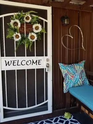 a door with a welcome sign and a blue bench at Red Barn Haven-Your romantic getaway to Yosemite in Oakhurst