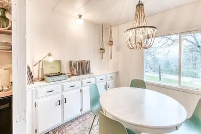 a kitchen with a white table and chairs at Yosemite Boho Bungalow, Pet Friendly & Mtn Views! in Coarsegold