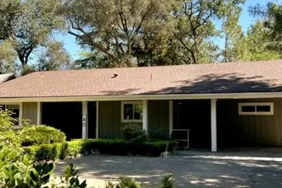 a green house with a brown roof at River Retreat near Sequoia National Park in Three Rivers