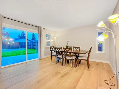 a dining room with a table and chairs and a large window at Spacious 4BR Family Home Free Parking, Fast WiFi, Near Galleria & Fountains in Roseville