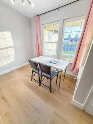 a table and chairs in a room with windows at Spacious 4BR Family Home Free Parking, Fast WiFi, Near Galleria & Fountains in Roseville