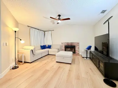 a living room with a white couch and a fireplace at Spacious 4BR Family Home Free Parking, Fast WiFi, Near Galleria & Fountains in Roseville