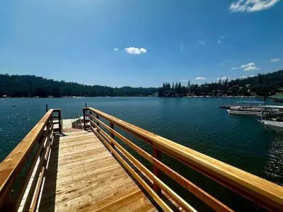 a wooden bridge over a large body of water at Fox Cabin - Lakefront - Sleeps 4 in Bass Lake