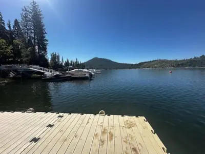 a dock on a lake with boats in the water at Fox Cabin - Lakefront - Sleeps 4 in Bass Lake