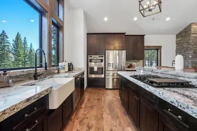 a kitchen with stainless steel appliances and wooden cabinets at Paradise on Pioneer - New 6 Bedroom w Pool Table in South Lake Tahoe