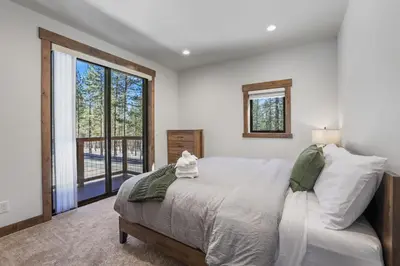 a bedroom with a bed and a large window at Paradise on Pioneer - New 6 Bedroom w Pool Table in South Lake Tahoe