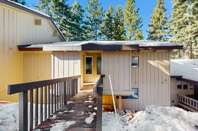a yellow house with a porch in the snow at Tahoe Summit Escape in Incline Village
