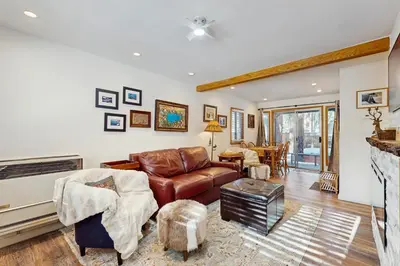 a living room with a leather couch and a fireplace at Aspen Pines Chalet in South Lake Tahoe