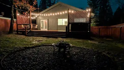 a small house with lights on it in a yard at Sierra Cabin w NEW Hot Tub Walk to Town in Twain Harte